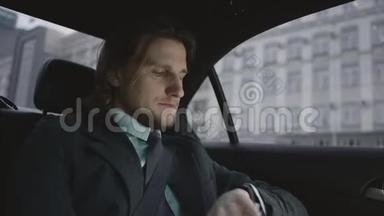 穿着开心果衬衫和灰色西装的棕色头发的人坐在车上，系安全带，四处张望